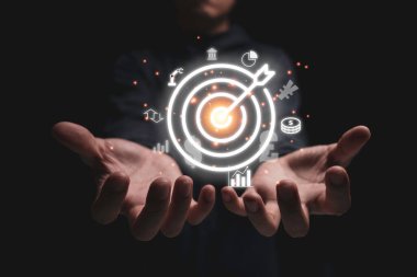 Grafik para Yuan ve dolar gibi iş simgeleriyle el ele tutuşan sanal hedef tahtası. Hedef ve yatırım hedefi kavramı.