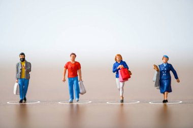 Alışveriş merkezindeki küçük insanlar COVID-19 korona virüsünün yayılmasını ve salgın hastalığın yayılmasını önlemek için alışveriş merkezlerindeki ve kamu alanlarındaki mesafelerini koruyorlar. Sosyal uzaklık kavramı.