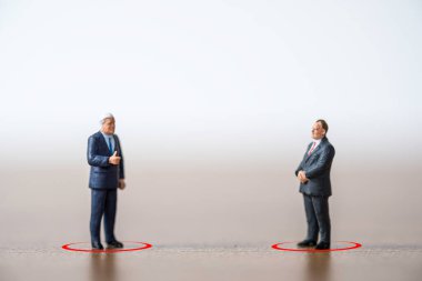 İki iş adamı COVID-19 Corona virüsü salgınının yayılmasını önlemek için sosyal mesafeyi koruyorlar. Sosyal uzaklık kavramı.