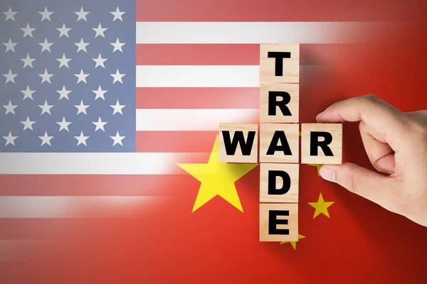 Hand putting trade war wording on USA and China flag.It is symbol of tariff trade war tax barrier between United States of America and China.-Image.