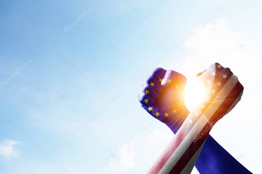 USA flag and EU flag print screen fists and wrestling with blue sky and sunlight. United States of America and European Union have conflicted and barrier tariffs trade war.