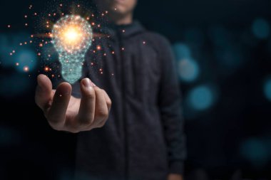 İş adamı elinde turuncu ışıklı, parlayan bir ampul tutuyor. Yaratıcı yeni iş fikri kavramı.