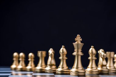 Diğer satranç taşlarının önünde altın kral satranç standı. Liderlik işi takım çalışması ve pazarlama stratejisi planlama kavramı.
