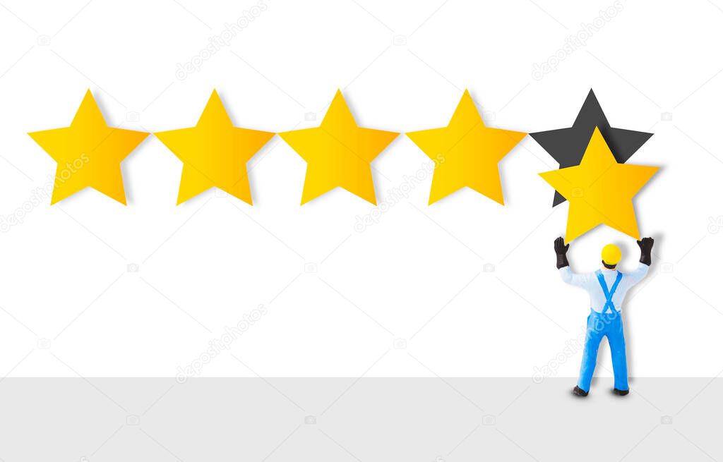 Miniature figure worker staff holding a gold star in hand to give five star for customer evaluation. Customer satisfaction and marketing survey concept.