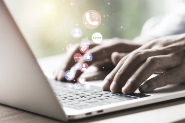 Elinde mavi ışıklı tablet ve sosyal medya simgeleri olan bir iş adamı mavi bokeh arka planda. Pazarlama kavramına sahip sosyal medya.