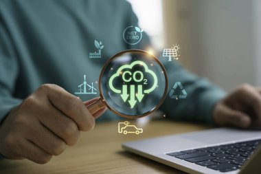 Elde tutulan büyüteç net sıfır için CO2 emisyon azalması, yenilenebilir enerji ve çevre koruma ve yeşil teknoloji çevresel sürdürülebilirlik kavramı.