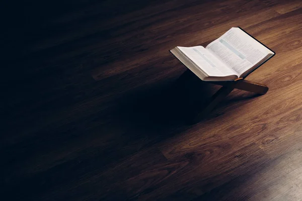 Biblia Abierta Soporte Libro Sobre Fondo Negro Con Suelo Madera —  Fotos de Stock