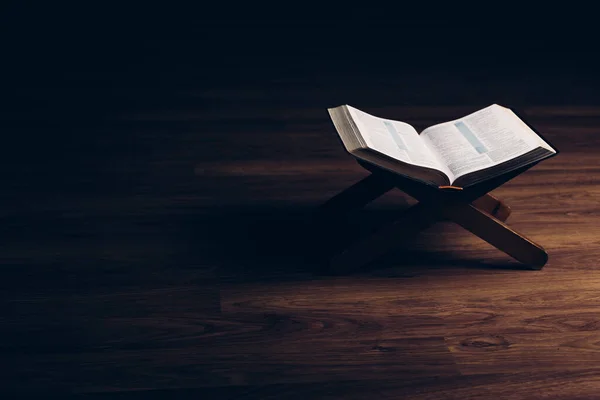 Open Bijbel Een Boekenstandaard Een Zwarte Achtergrond Met Een Houten — Stockfoto