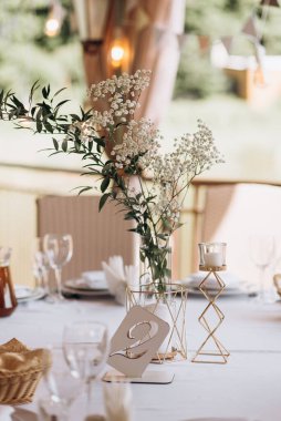 Masa numarası ve beyaz şenlik masasında beyaz çiçekler. Masa numarası 2