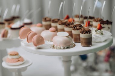 Çikolata. Lezzetli çöreklerle dolu tatlı masası, pembe kurabiyeler, pastalar, şekerlemeler. Marshmallow 'un tepesinde çilek