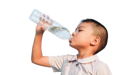 6 yaşındaki bir çocuğun portresi. Mutlu Asyalı çocuk plastik şişenin yanında su içiyor. Egzersiz bittikten sonra. Sağlıklı bir çocuk. Yaz sezonu. Beyaz arkaplanda izole.