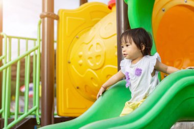 2 yaşındaki bir bebeğin portresi. Mutlu Asyalı kız çocuğu gülümsüyor ve gülüyor. Çocuk parkında sürgülü bar oyuncağıyla oynuyor. Çocuk konseptini öğrenmek ve aktif olmak.