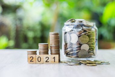 Ahşap masanın üzerine büyüyen bir grafik gibi bozuk paralar konuyor. Yeşil bulanık bokeh arkaplanda. Ve uzayı kopyala. Tasarruf ve finans kavramı.