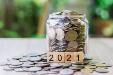 Ahşap masanın üzerine büyüyen bir grafik gibi bozuk paralar konuyor. Yeşil bulanık bokeh arkaplanda. Ve uzayı kopyala. Tasarruf ve finans kavramı.