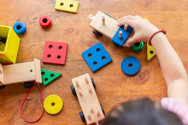 Tahta blok oyuncaklarıyla oynayan erkek ya da kız çocuğunun en iyi görüntüsü. Ahşap zeminde. 1-2 yaşlarında bir çocuk. Çocuk kavramının öğrenilmesi ve geliştirilmesi.