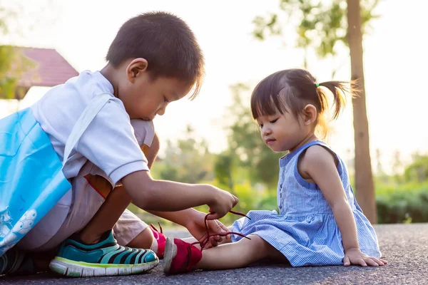 Jovem Irmão Asiático Ajuda Sua Irmãzinha Amarrar Seus Cadarços Parque — Fotografia de Stock