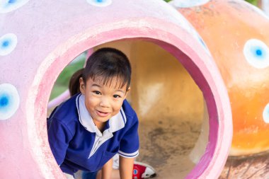 5 yaşındaki bir çocuğun portresi. Parkta oyuncaklarla oynayan mutlu Asyalı çocuk. Bağırıyor ve gülüyor. Tatlı gülümsemeli çocuk.