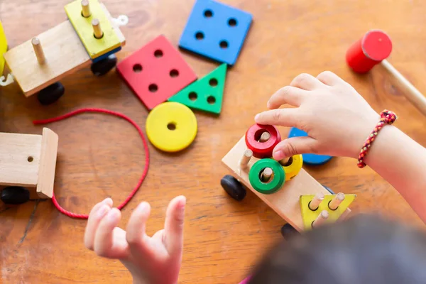 Tahta blok oyuncaklarıyla oynayan erkek ya da kız çocuğunun en iyi görüntüsü. Ahşap zeminde. 2 yaşında bir çocuk. Çocuk kavramının öğrenilmesi ve geliştirilmesi.
