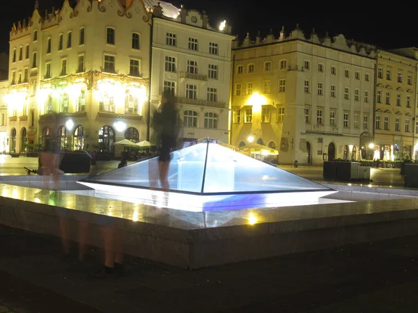 Krakow Rynek 'te gece görüşlü binalarda hayalet gibi insanların gölgeleri var.
