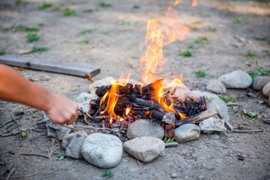 Geceleri yanan orman. Dağlardaki bir turist kampında kamp ateşi. Ateş ve alev, soyut ve karanlık bir arkaplanda kıvılcımlar saçar. Açık havada barbekü hazırlıyoruz. Cehennem ateşi elementi. Yakıt, güç ve enerji. Su kenarında şenlik ateşi.