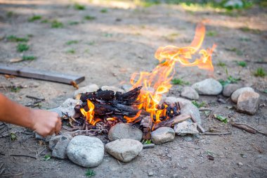 Geceleri yanan orman. Dağlardaki bir turist kampında kamp ateşi. Ateş ve alev, soyut ve karanlık bir arkaplanda kıvılcımlar saçar. Açık havada barbekü hazırlıyoruz. Cehennem ateşi elementi. Yakıt, güç ve enerji. Su kenarında şenlik ateşi.