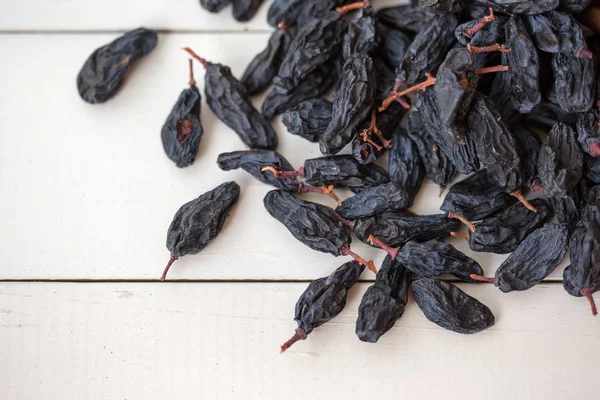 Black Raisins White Wooden Ground — Stock Photo, Image