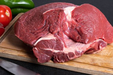 Kesme tahtasının üzerinde kırmızı biber ve yeşil biberli bir bıçakla.