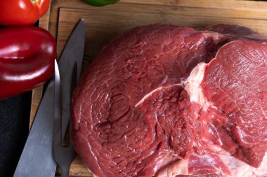 Kesme tahtasının üzerinde kırmızı biber ve yeşil biberli bir bıçakla.