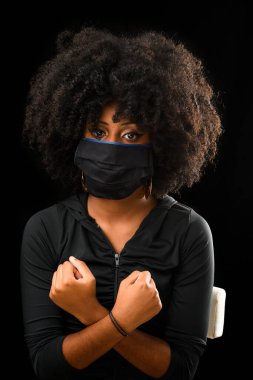 Siyah saçlı, siyah saçlı bir kız. Kovid 19 tıbbi maske takıyor.