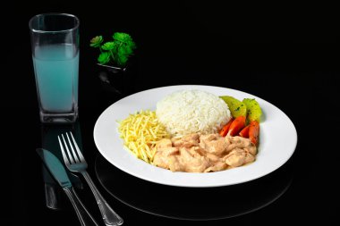 sığır stroganoff beyaz pirinç, patates kamışı ve pişirilmiş sebzelerle servis edilir.