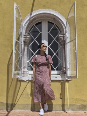 Sarı atari salonunda poz veren şık kız sarı pencereye poz veriyor.