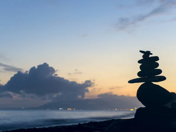 Close up of a pile of stones in the beach at sunset with blurr background. Zen & Spa Concept.