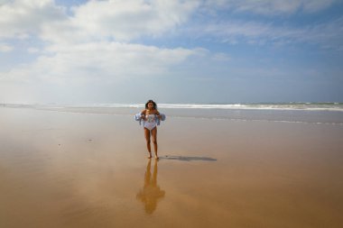 Plajda mayo ve şapkalı bir kız. Atlantik Okyanusu Agadir Fas.