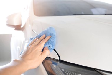 Mavi bir bez tutan bir adamın eli, bakım arabası beyaz ve temizlik ve makine dairesi