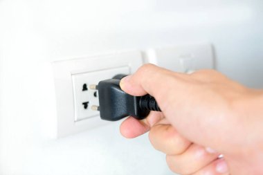 Elektrik Cihazları 'nın Eli fişi çekiyordu. Fişi çek. Çalışma saatlerinde ofisinde. Enerji Tasarruf Kavramları ve Teknolojileri
