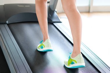 Spor salonunda koşu bandında koşan kadının bacağı koşu ayakkabılarıyla atletik koşuyor. Sağlık ve spor konsepti geçmişi,