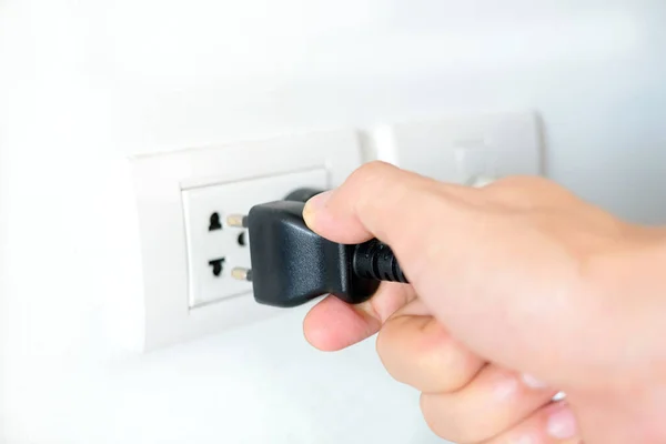 Hand of Electrical Appliances He was pulling the plug. Out of the plug. In his office during work hours. Energy Saving Concepts and Technologies