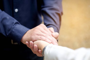 Kadın ve erkek el ele tutuşup birbirlerine yardım ediyorlar..