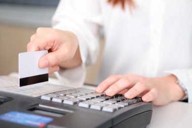 Kredi kartı tutan kadının eli. Lokantada faturaları ödemek için kredi kartı makinesi kullanıyor. Finansal kavramlar ve iş dünyası.