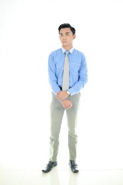 Güven ve iş kavramı. Mavi yakalı gömlekli başarılı genç girişimci portresi, kendinden emin ifadesiyle geniş bir gülümseme ile izole edilmiş Beyaz Arka plan. Endonezya Halkı