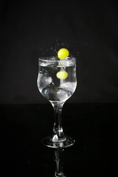 Wasser Spritzt Aus Glas Auf Schwarzem Hintergrund Mit Grünen Trauben — Stockfoto