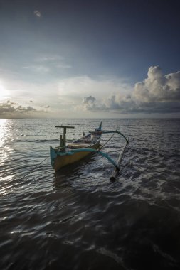 Endonezya geleneksel ahşap gemiler ve güzel kumsallar. Geleneksel Sasaknese teknesi Jukung Mlandingan sahilinde, Situbondo. Gün batımında sahilde balıkçı teknesi.