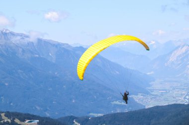 Paraglider güzel dağların üzerinde mavi gökyüzünde süzülüyor..