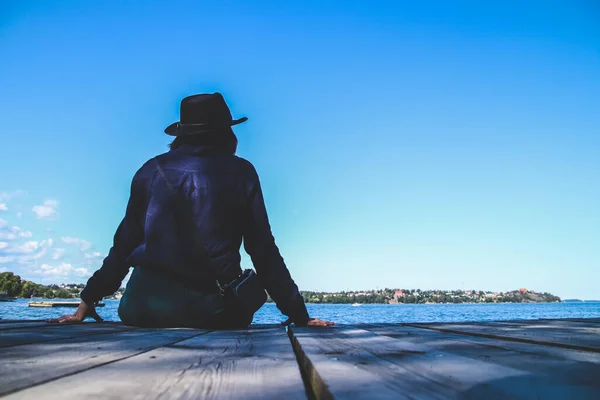 Samotna Kobieta Siedząca Drewnianym Molo Nad Morzem Błękitnym Niebem — Zdjęcie stockowe