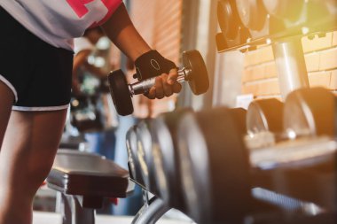 Kapalı kadınlar spor salonunda halterlerini kaldırıyor ve halterleri askıda..