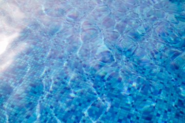 Sualtı kiremitlerine tepeden bakan yüzme havuzunda dalgalı su.