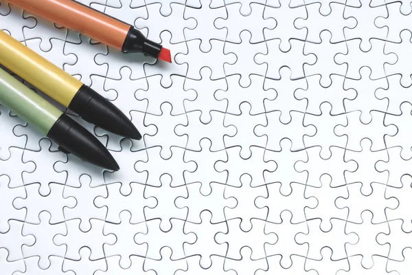 白いジグソーパズルの背景にカラフルなマーカーペン — ストック写真