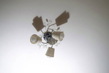 Tavandaki avizenin güzel gölgesi, üç lamba.