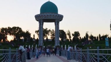 Taşkent 'teki anıt kompleksinin yanında bir köprü, akşam, insanlar köprüde yürüyor ve dinleniyor, zaman geçiyor.