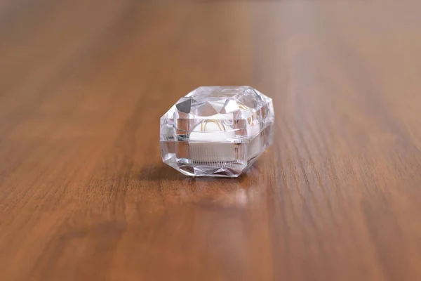 Uma Caixa Cristal Com Anéis Casamento Uma Mesa Madeira — Fotografia de Stock